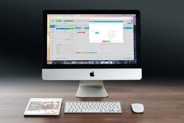 Silver Imac, Apple Magic Keyboard, and Magic Mouse on Wooden Table